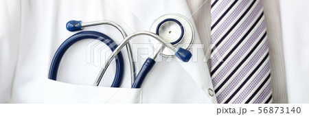 Male GP wearing tie holding stethoscope in smock pocket 56873140