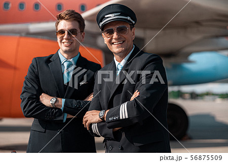 Adult men in uniform posing for camera in airport 56875509