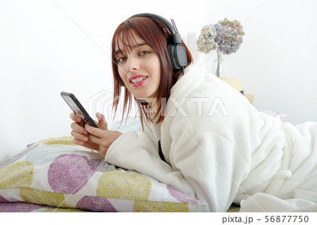 beautiful young girl listening to music in her bed beautiful young girl listening to music in her bed 56877750