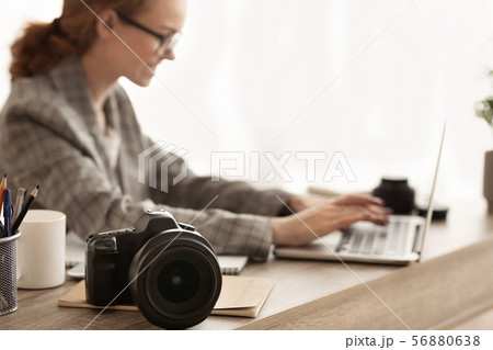 Woman working with photocamera and laptop, off loading files 56880638