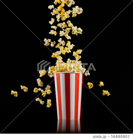 Paper striped bucket with popcorn isolated on black background 56880802