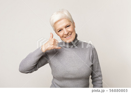 Beautiful aged lady making call me gesture with her hand 56880803