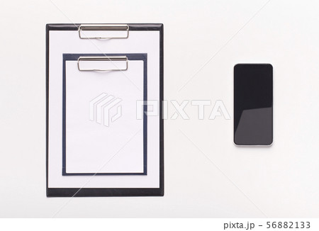 Two different sized clipboards and cellphone with blank screen Two different sized clipboards and cellphone with blank screen 56882133