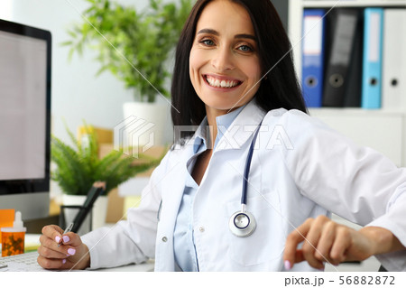 Mature GP holding silver pen looking in camera Mature GP holding silver pen looking in camera 56882872