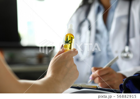 Visitor hand holding jar of cannabis concentrate oil 56882915