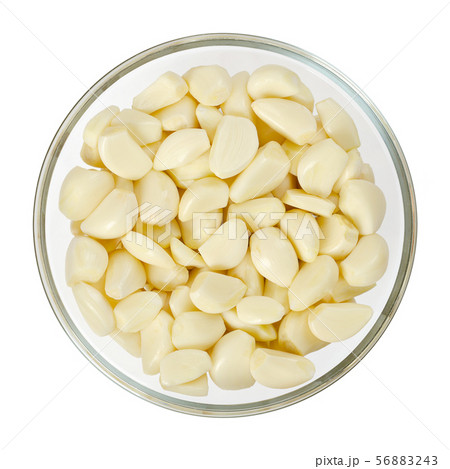 Peeled garlic cloves in glass bowl, from above 56883243