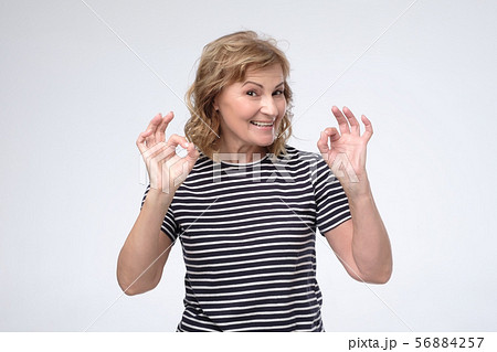 Mature caucasian smiling woman showing ok sign Mature caucasian smiling woman showing ok sign 56884257