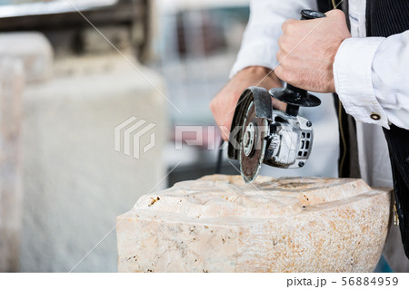 Stonemason cutting marble with angle grinder Stonemason cutting marble with angle grinder 56884959