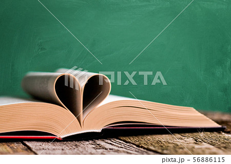 Open book and pages folded in the shape of a heart 56886115