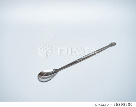 long stainless steel spoon in light grey background 56898200