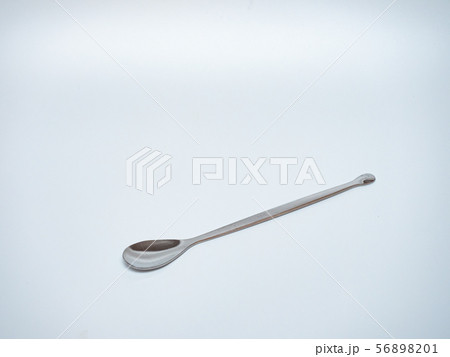 long stainless steel spoon in light grey background long stainless steel spoon in light grey background 56898201