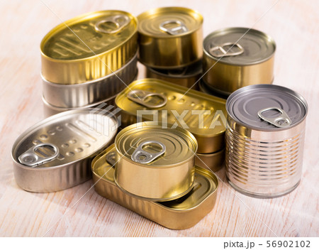Close-up of metal tin cans with ring pull on wooden surface Close-up of metal tin cans with ring pull on wooden surface 56902102