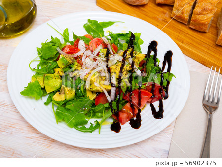 Salad with arugula, green avocado, tomato and onion with balsamic Salad with arugula, green avocado, tomato and onion with balsamic 56902375