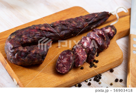 French tasty slicing dry-cured sausage with liver at wooden desk 56903418