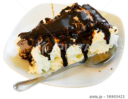 Slice of tasty chocolate cake served on white plate with whipped cream Slice of tasty chocolate cake served on white plate with whipped cream 56903423