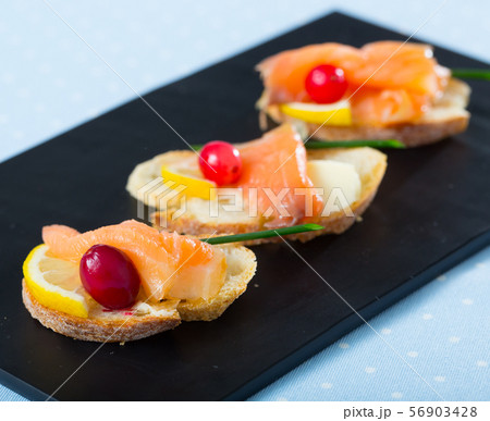 Canapes with salmon, butter and cranberries 56903428