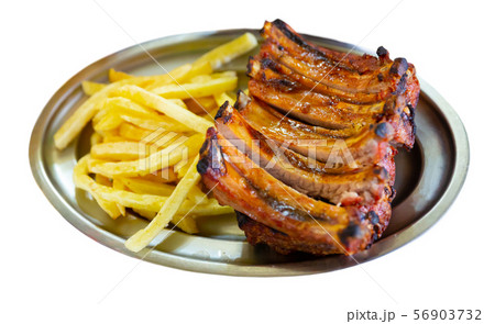Grilled pork ribs with french fries, served with tomatoe sause 56903732