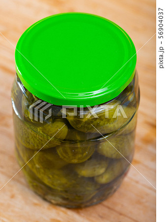 Glass jar with pickled cucumbers on wooden background 56904037