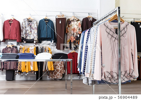 Many elegant clothes on hangers and shelfs 56904489