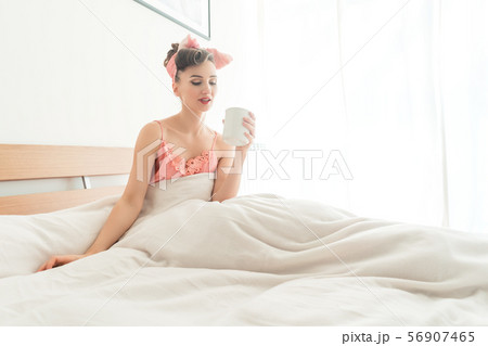 Beautiful woman sipping her morning coffee still in bed 56907465