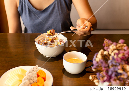 Healthy woman eating corn flakes cereal and coffee for breakfast on table. Healthy woman eating corn flakes cereal and coffee for breakfast on table. 56909919