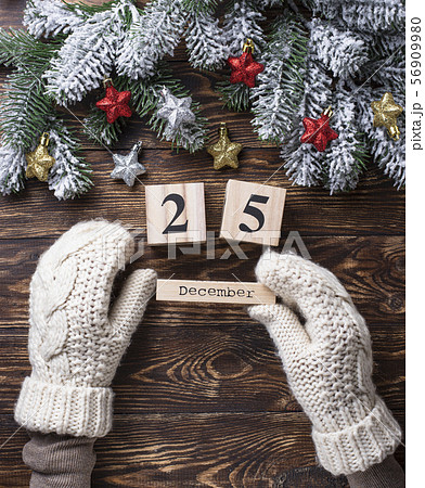 写真素材: Hands in mittens holding wooden calendar