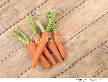 Fresh raw carrots on a wooden table. Fresh raw carrots on a wooden table. 56910482
