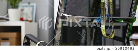 Measuring ribbons hanging on a black chair 56910493