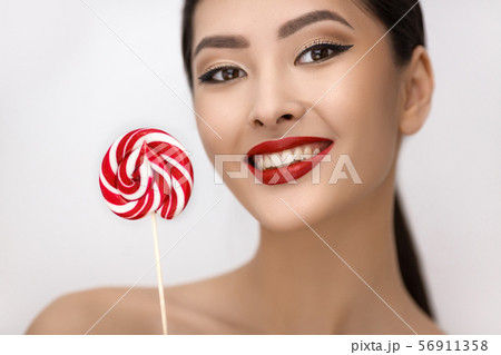 Fashion Portrait of Asian Woman with Lollipop in Studio Fashion Portrait of Asian Woman with Lollipop in Studio 56911358