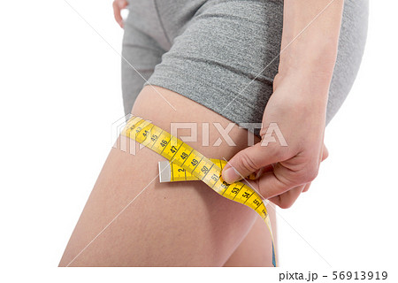 young woman is measuring her thigh young woman is measuring her thigh 56913919