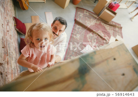 Young father and his daughter moved to a new house or apartment Young father and his daughter moved to a new house or apartment 56914643