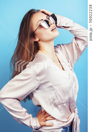 young pretty girl in sunglasses posing happy smiling on blue background, lifestyle people on summer young pretty girl in sunglasses posing happy smiling on blue background, lifestyle people on summer 56922238