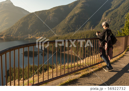 A young woman with white hair takes photographs with her smartphone of Diablo Lake, in North 56922732