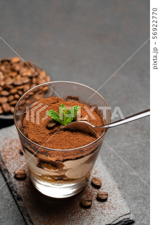 Portion of Classic tiramisu dessert in a glass cup on dark concrete background 56922770