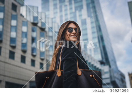 Young beautiful stylish girl in Sunglasses walking on street. Close up portrait of woman is turn 56924096