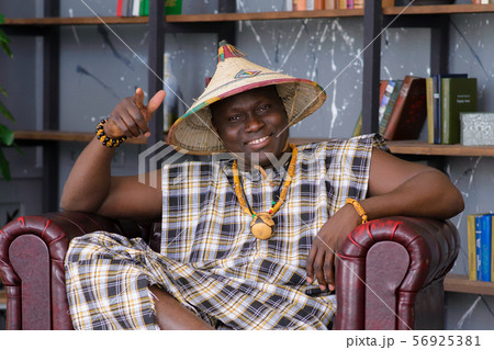 Happy Handsome african man in traditional clothes sitting on chair 56925381
