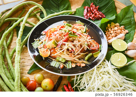 Papaya salad served on wooden dining table - Green Papaya salad served on wooden dining table - Green 56926346