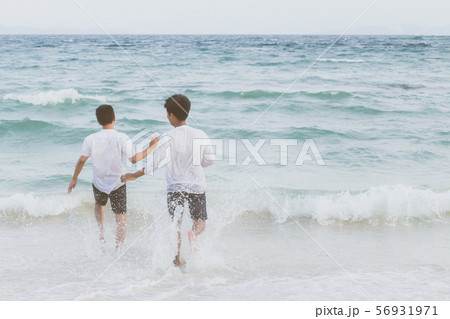 Homosexual young asian couple running on beach Homosexual young asian couple running on beach 56931971