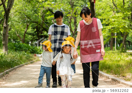 公園を散歩する保育士と園児 56932202