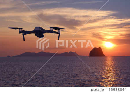 Drones while flying in the sky at sunset, Ocean Drones while flying in the sky at sunset, Ocean 56938044