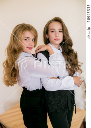 Two girls schoolgirls in fashionable school clothes.  56943353