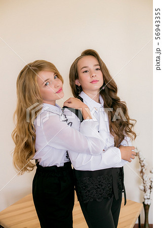Two girls schoolgirls in fashionable school clothes. Two girls schoolgirls in fashionable school clothes. 56943355