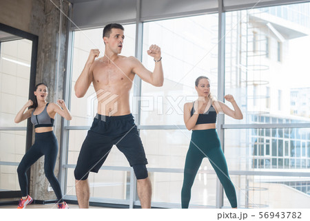 Fitness training in the studio - two young women training with their athletic coach - boxing 56943782