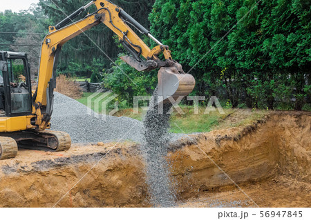 A yellow excavator bucket shovel moving stones A yellow excavator bucket shovel moving stones 56947845