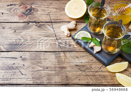 Two cups of natural herbal tea ginger lemon mint and honey on a wooden background. Copy space 56949668