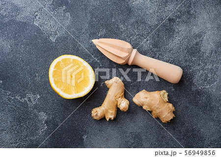 Lemon and ginger root on dark grey background with copy space. Ingredients for a tonic vitamin drink. Lemon and ginger root on dark grey background with copy space. Ingredients for a tonic vitamin drink. 56949856