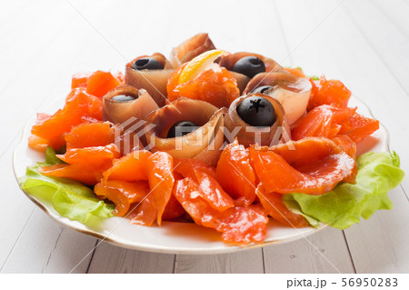 Gourmet restaurant serving a plate of smoked salt, raw white fish fillets and salmon. Gourmet restaurant serving a plate of smoked salt, raw white fish fillets and salmon. 56950283