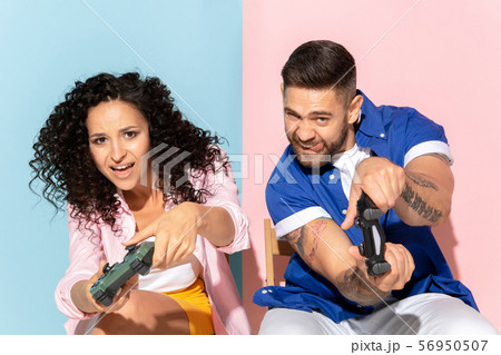 Young emotional man and woman on pink and blue background Young emotional man and woman on pink and blue background 56950507