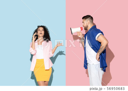 Young emotional man and woman on pink and blue background 56950683