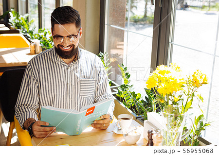 Happy positive man reading a book on the hindi language 56955068